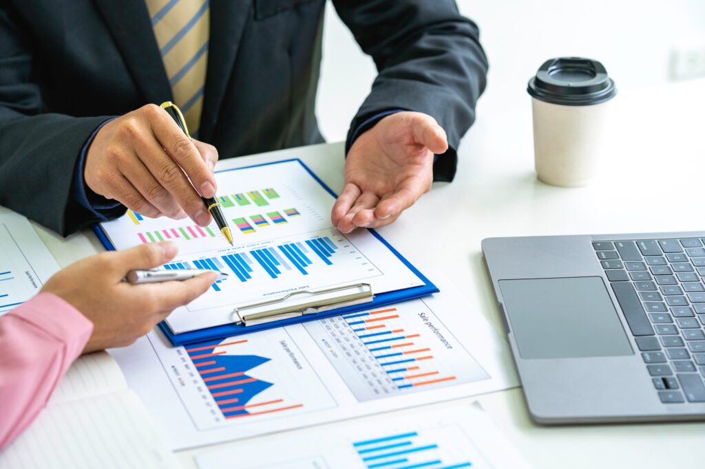 Marketers and financial accountants are discussing and analyzing charts to plan strategies to meet c